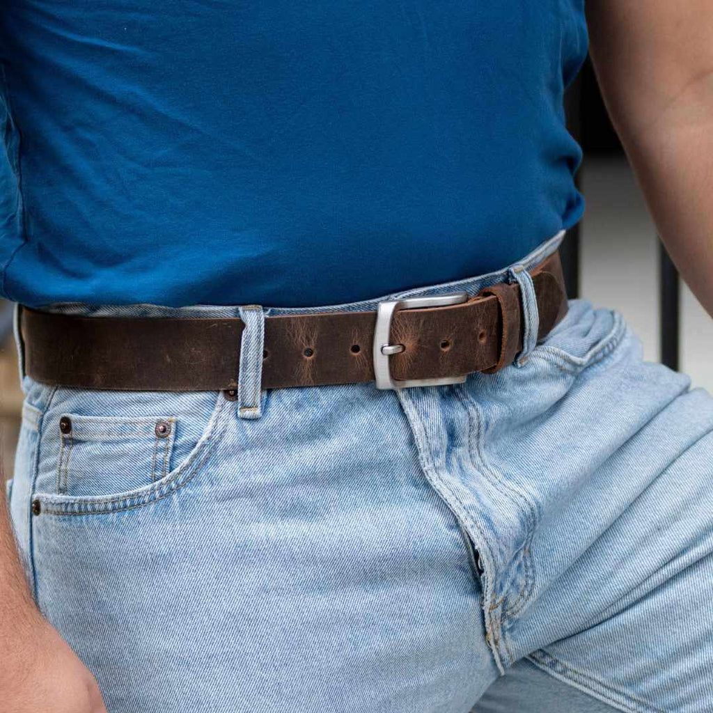 Silver, curved low profile buckle for sleek design with 1.5 inch distressed brown leather belt strap