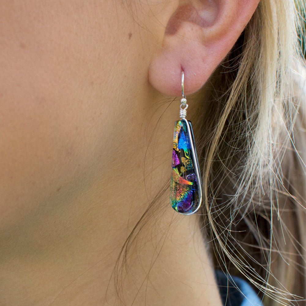 A swirl of Pinks, blues, purples in the dichroic glass. Tear drop shaped dangle earring. silver hook