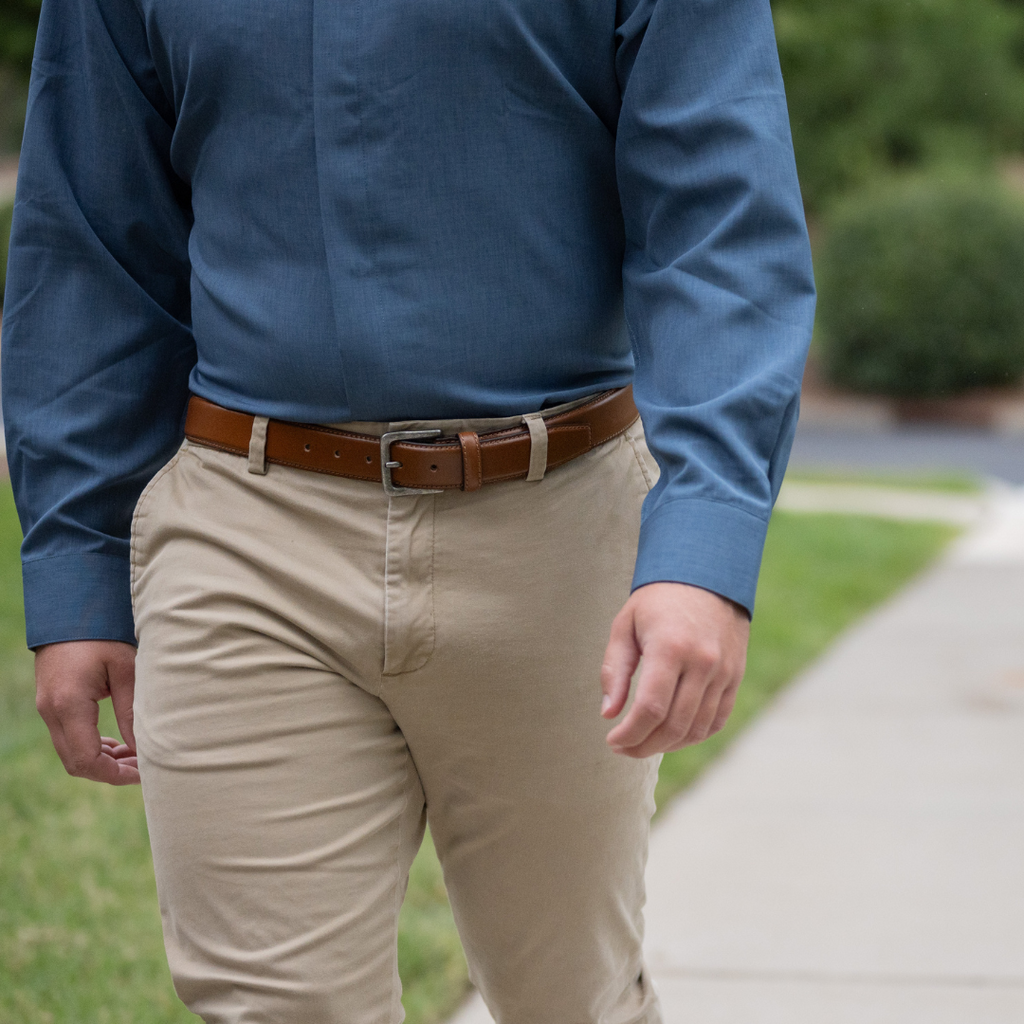 Explorer Tan Belt on a male model in khakis. Soft brown strap with a dark silver buckle.