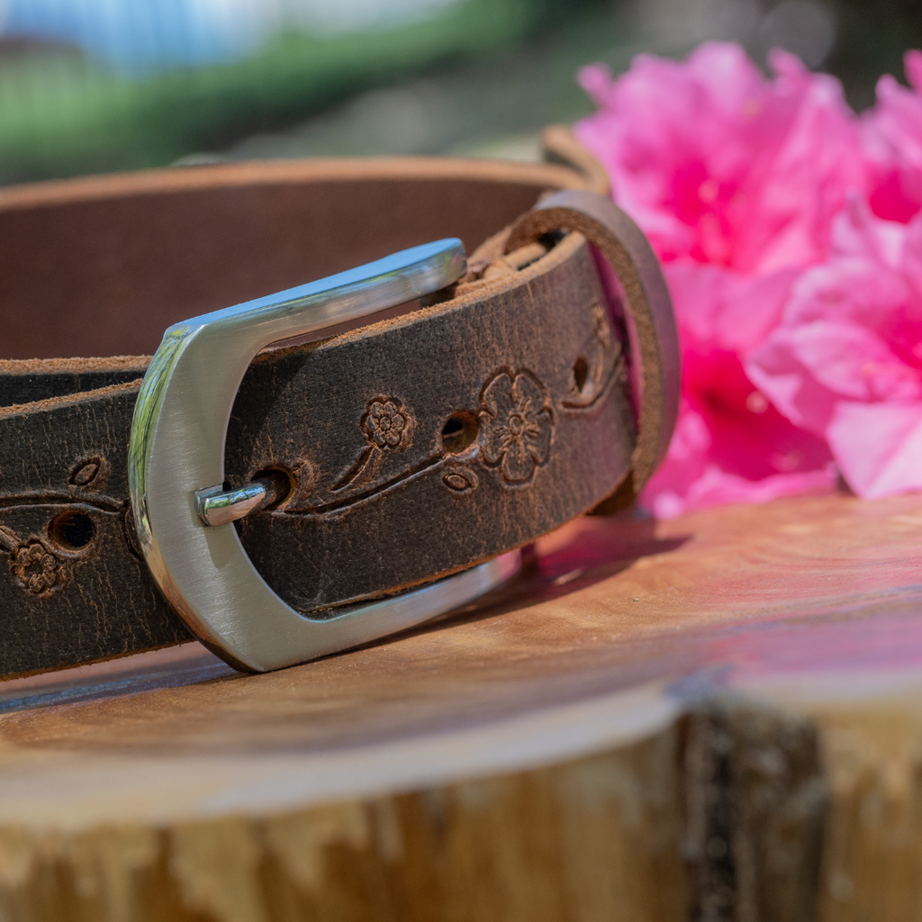 Brown distressed leather belt with rose pattern and leaves embossed into leather. Silver arch buckle