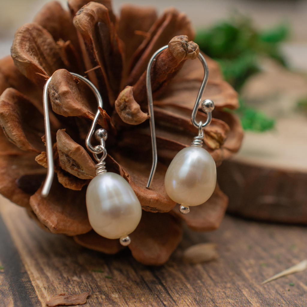 Dewberry Freshwater Pearl Dangle Earrings | French hook earrings on a pinecone background
