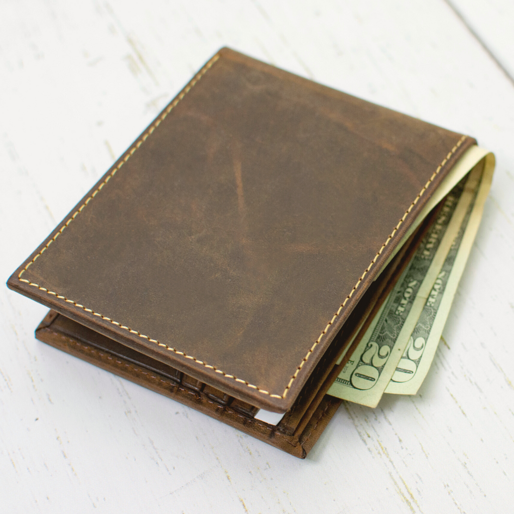 Randolph bifold wallet, closed with cash in the interior cash pocket. Single stitch around edges.