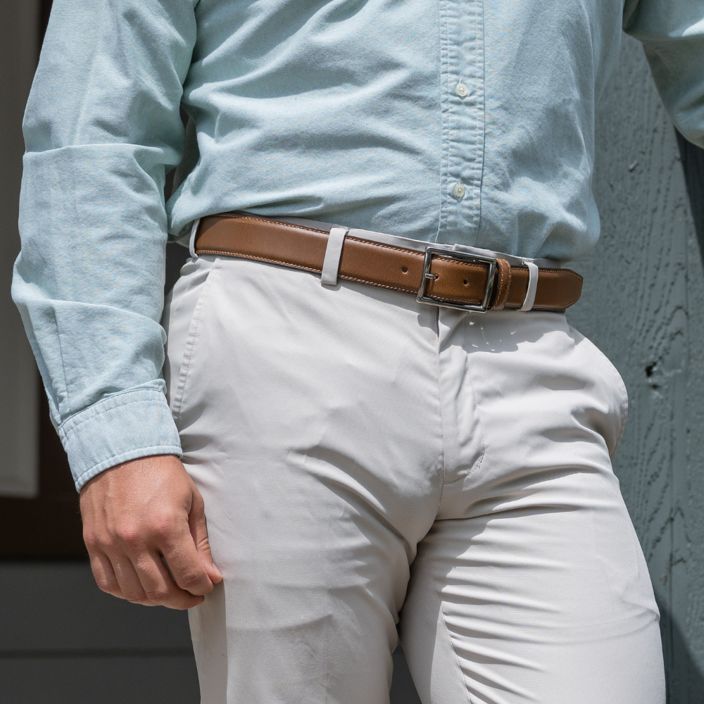 Model wearing Entrepreneur Tan Leather Belt. Silver tone buckle, domed strap with single stitching