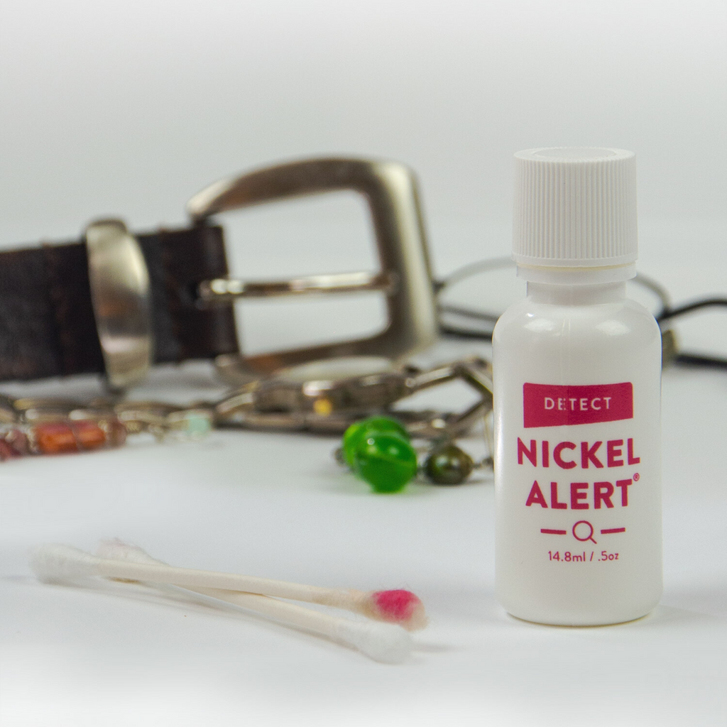 Nickel Alert bottle with a cotton swab with red color showing a positive test for nickel.