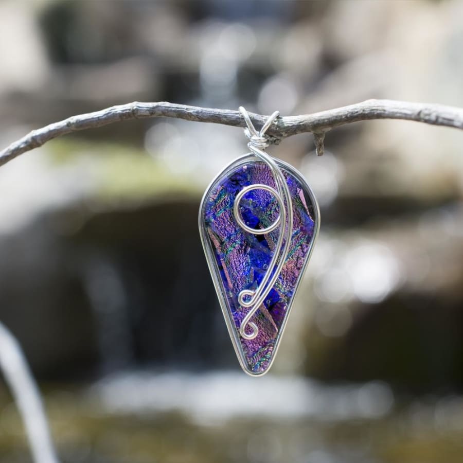  Dichroic glass pendant has shape of upside down tear drop. large end up, small end down.
